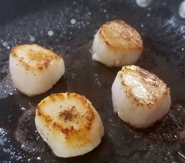 seared scallops cooking in pan