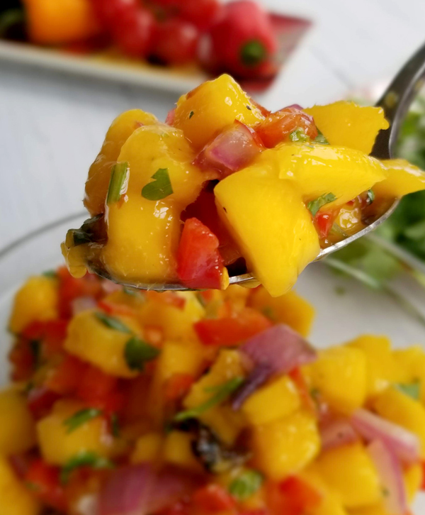 spicy mango salsa with spoon up close