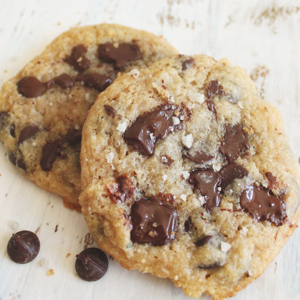 Close-up of two low-carb chocolate chip cookies showing golden texture and melted chocolate chips